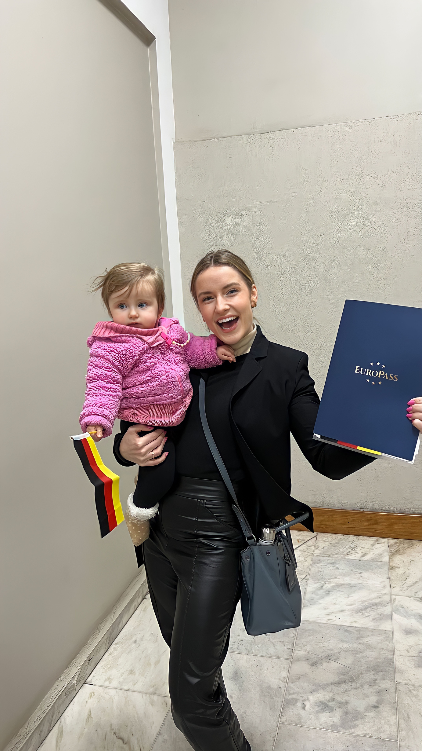 Cliente com a filha recebendo a Pasta Europass com bandeira da Alemanha