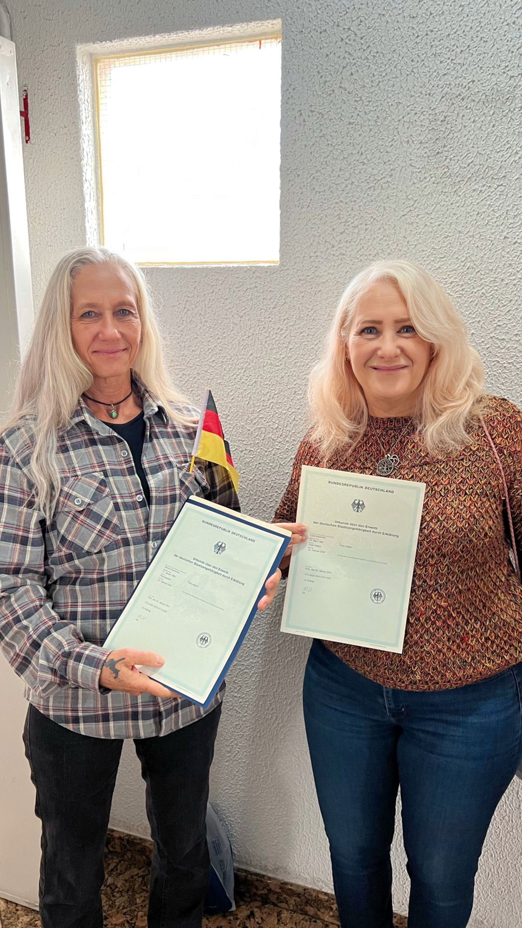 Duas clientes exibindo os certificados de cidadania alemã e certidões organizadas
